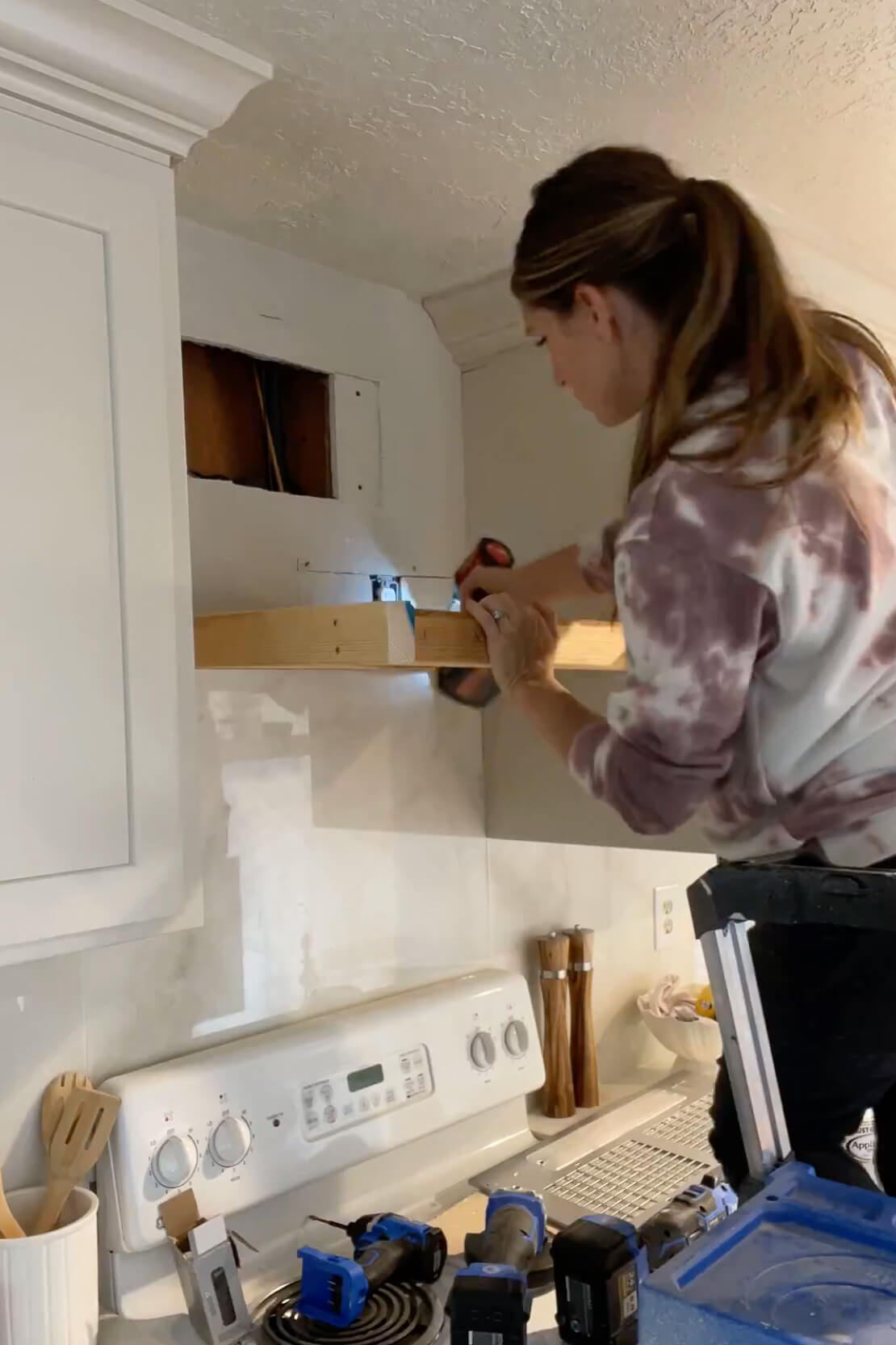 Attaching a range hood frame to the wall studs.